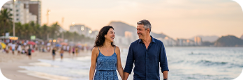 Casal caminhando de mãos dadas na praia